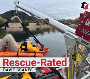 Rescue-rated davit crane lifting man over water in a rescue boat